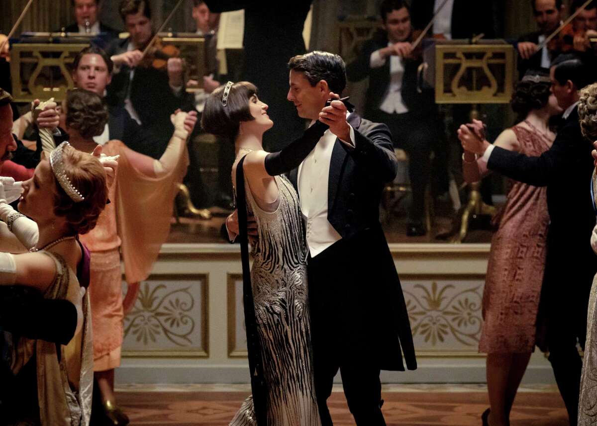 This image released by Focus features shows Michelle Dockery as Lady Mary Talbot, center left, and Matthew Goode as Henry Talbot in a scene from "Downton Abbey." The highly-anticipated film continuation of the "Masterpiece" series that wowed audiences for six seasons, will be released Sept. 13, 2019, in the United Kingdom and on Sept. 20 in the United States. (Jaap Buitendijk/Focus Features via AP)
