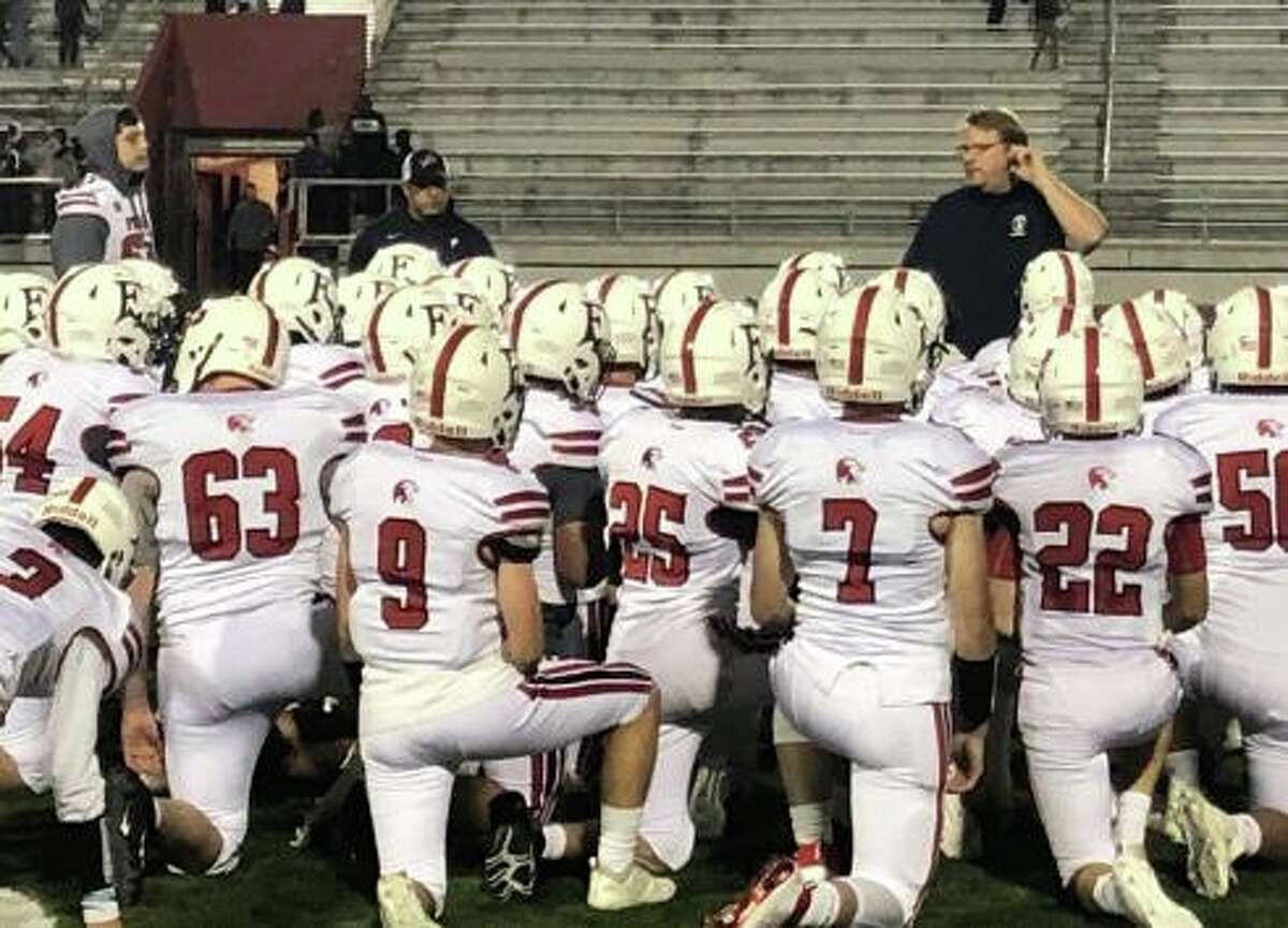Foran High coach Tom Drew talks to his team after the Lions win over Bassick.