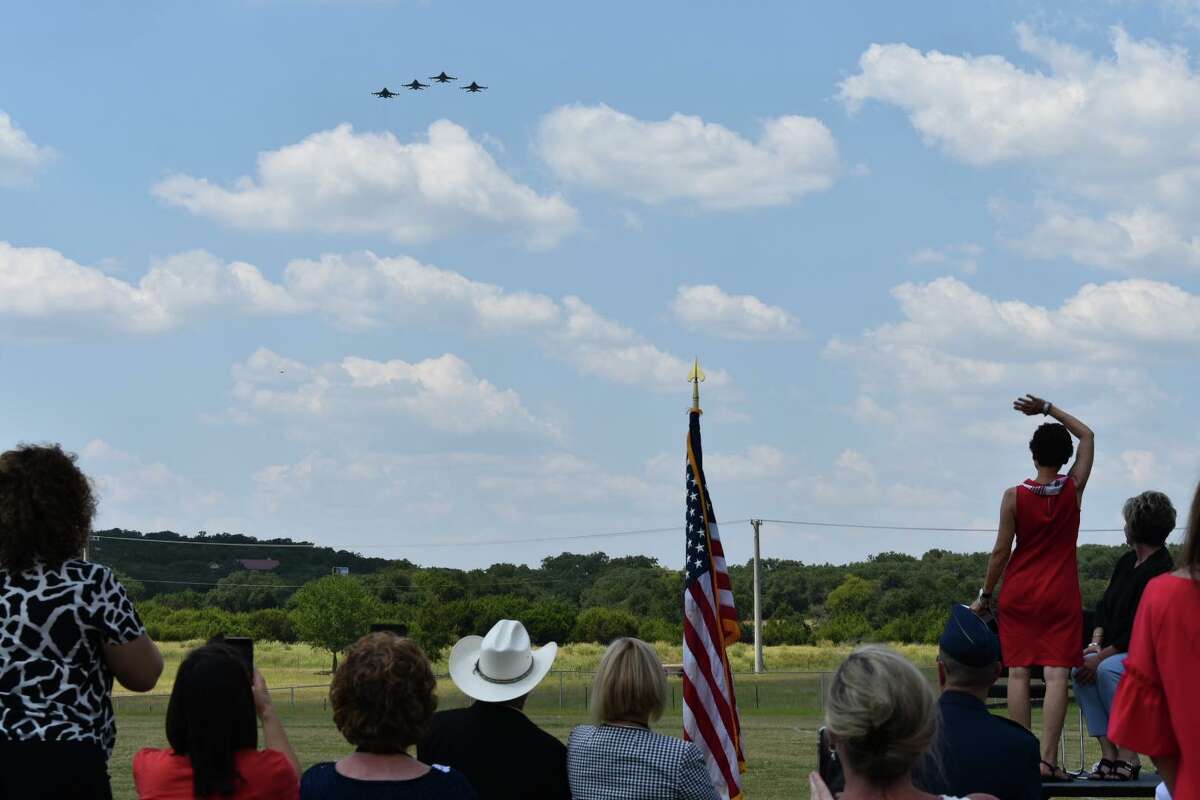 Marcy Voss appears to wave as US Air Force fighter jets fly the missing man formation in honor of her son, Capt. Mark Tyler Voss, during a Boerne ISD ribbon-cutting ceremony on Sept. 14.
