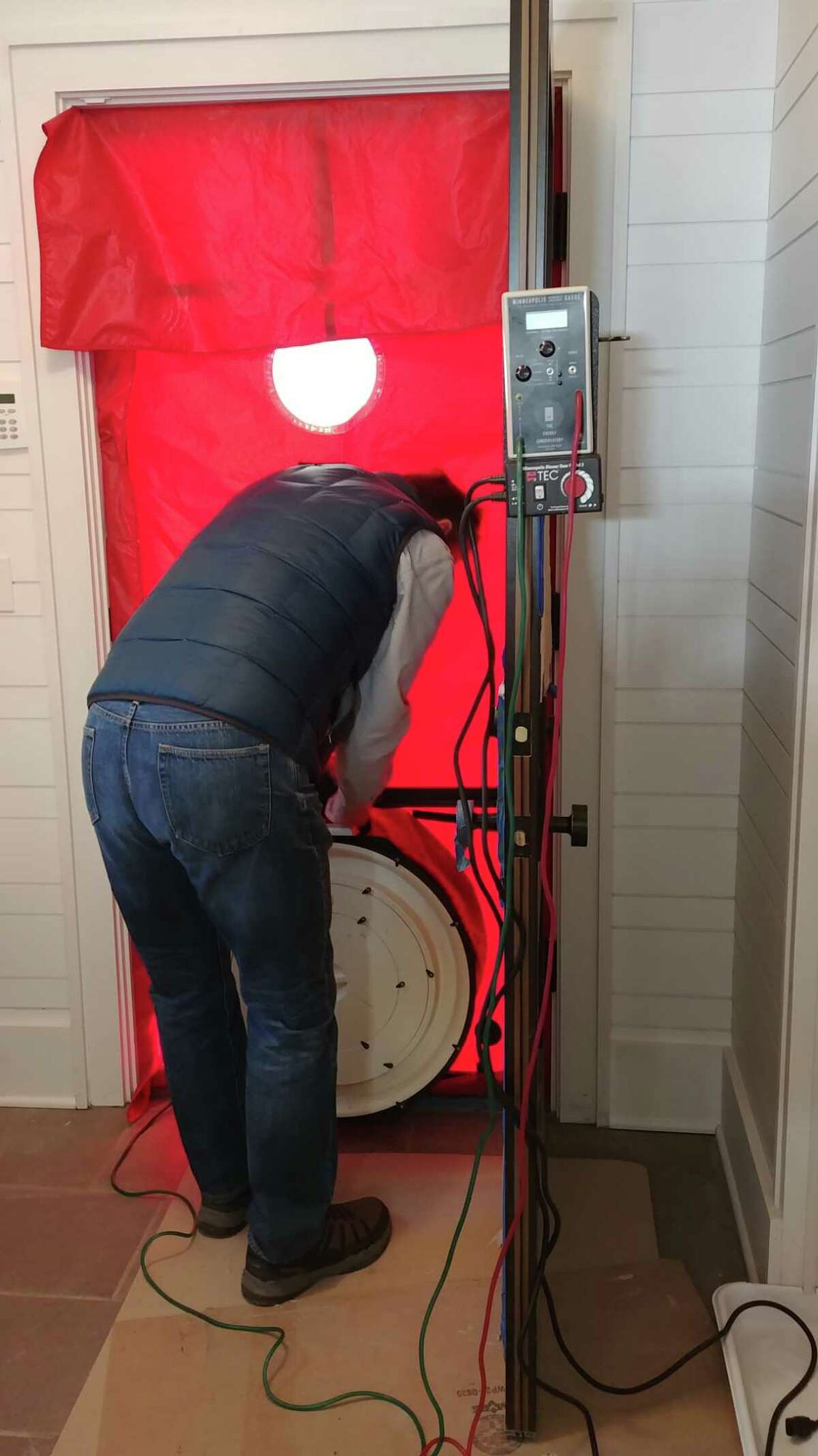 Stan Grajny conducts a blower door test on a new home built by Capital Construction in Malta, N.Y. The test involves placing a powerful fan into the frame of an exterior door in order to measure the airtightness of a structure. (Provided by Capital Construction)