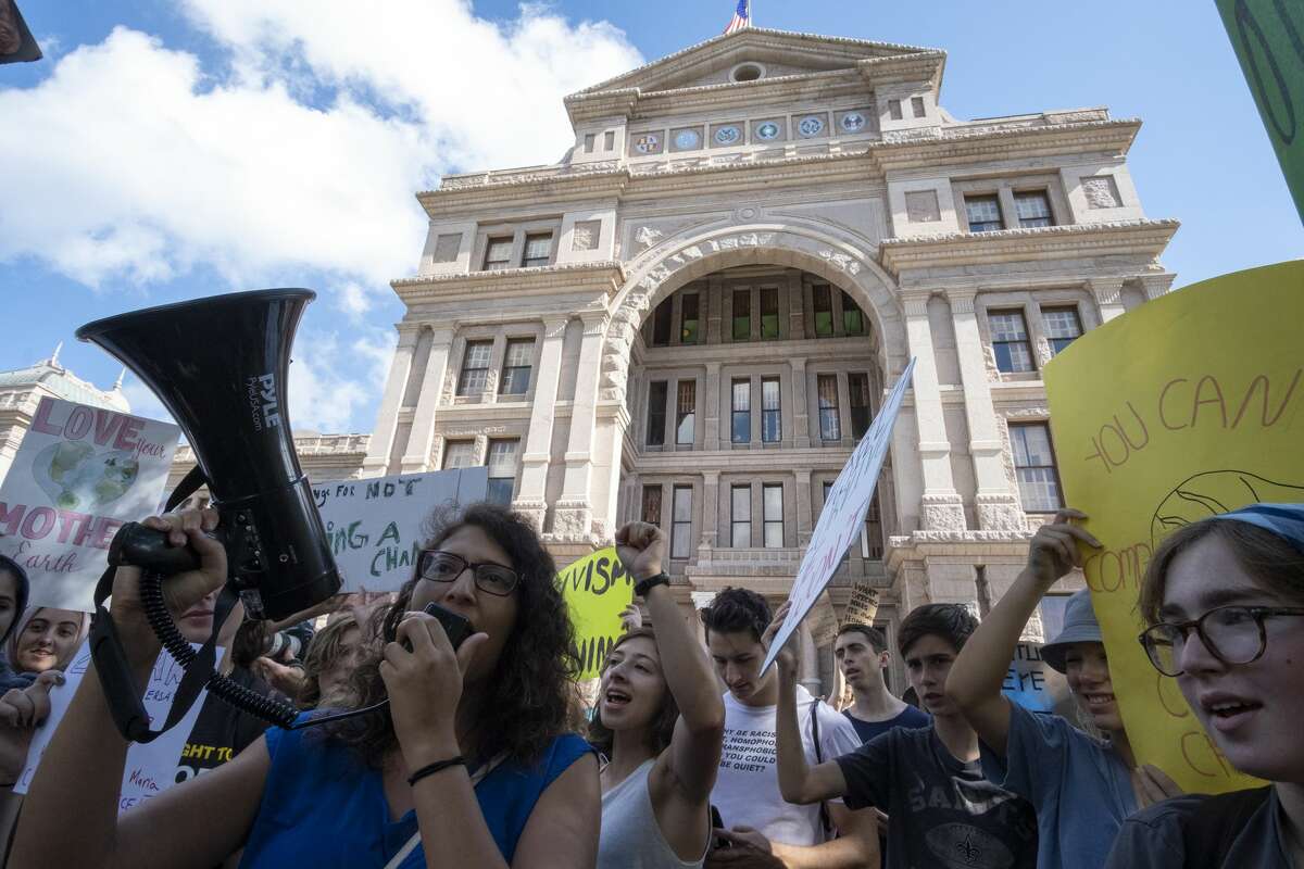 Sonia Torres Rodríguez uses a megaphone to lead chants at a climate strike at the Capitol building in Austin, Texas. [Dimitri Staszewski / San Antonio Express-News]