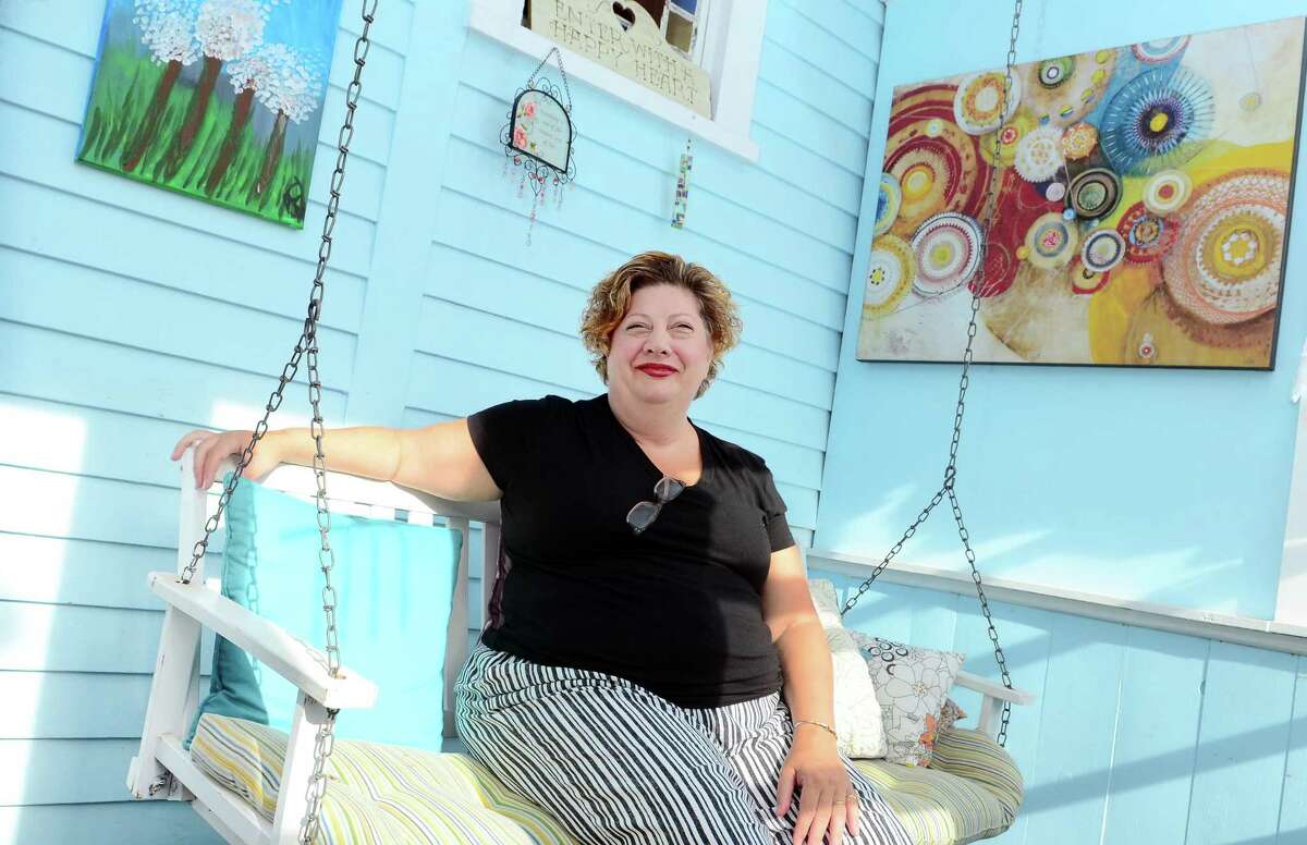 Juliet Novak poses at her home in West Haven, where she has rented space for short-term stays.