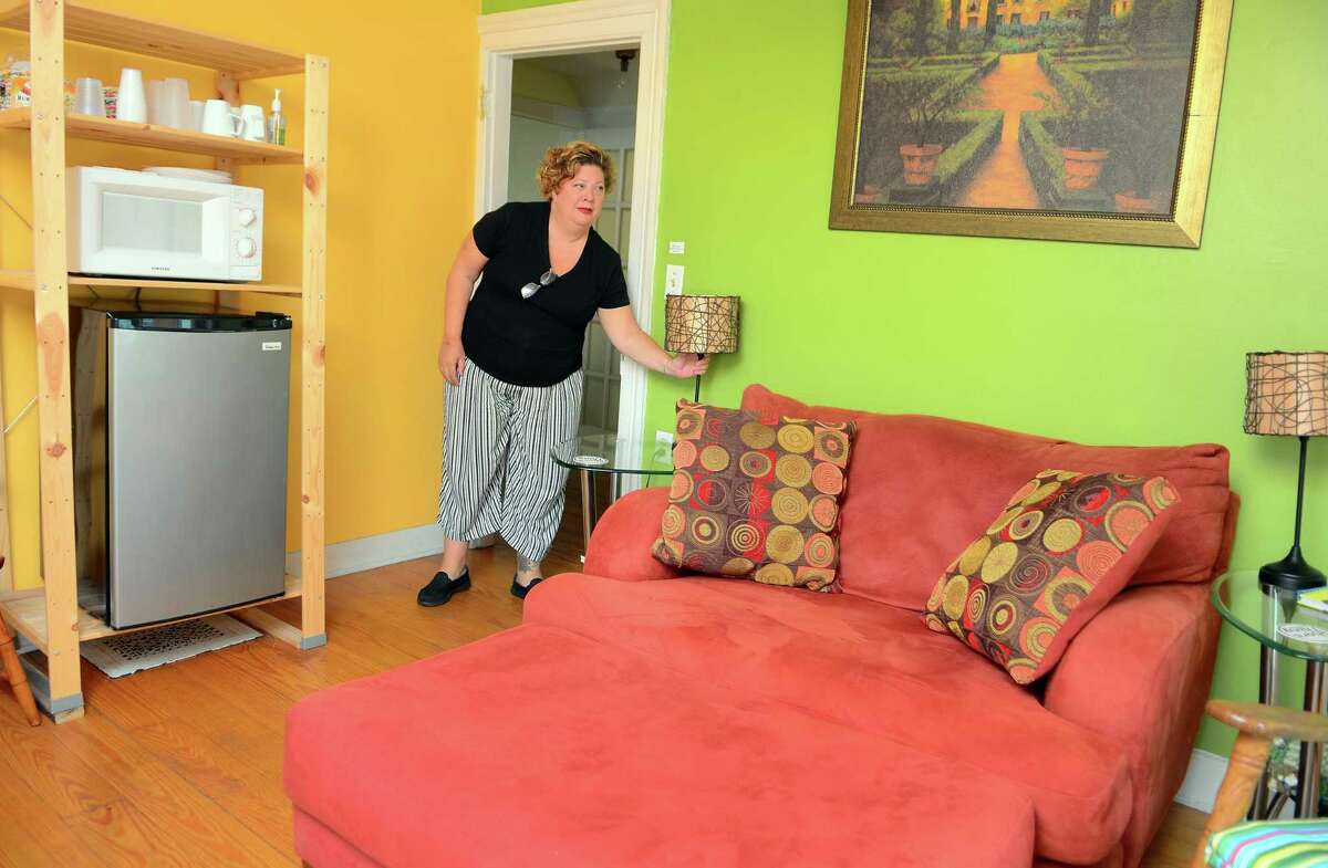 Juliet Novak shows one of the upstairs rooms she rents out for short-term stays.