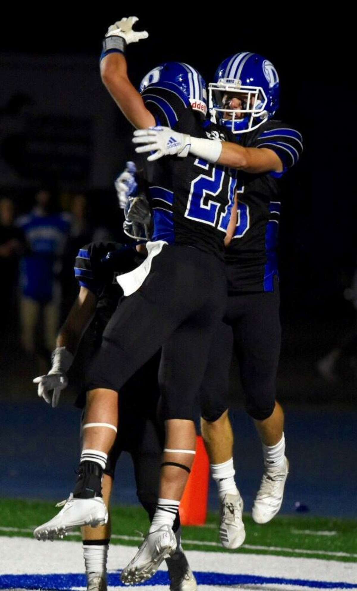 Darien’s Will Kirby (21) and Michael Minicus celebrate a touchdown during a football game against Southington at Darien on Friday.