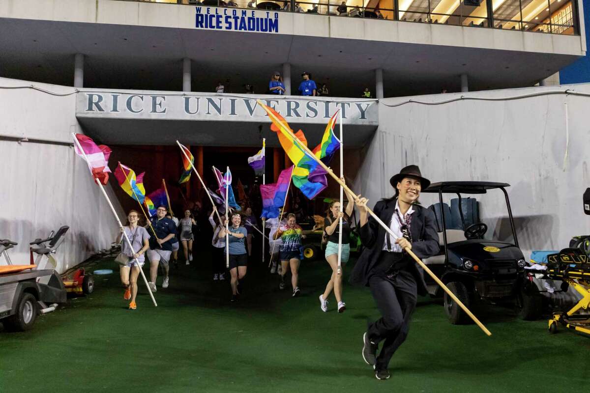 Rice students supporting the LGBTQ community rush onto the field to perform with the Marching Owl Band during halftime of the university’s game against Baylor on Saturday night.