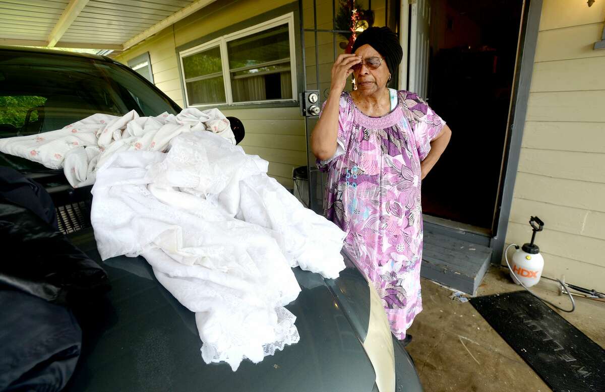 Katherine Briggs looks over flood soaked tablecloths as she and family begin cleaning up at her house on Roberts Avenue in Beaumont. Briggs, who bought the house in 2007, says she was awoken early Thursday morning by the noise of something falling over, and when she got up to put on her slippers her feet "went splash." "I made my pastor laugh when he called to check on me when I told him, 'I'm just sitting on my bed watching my shoes float by.'" Briggs and others throughout the area began the process of recovery from Imelda's torrential rains and flooding Friday. Photo taken Friday, September 20, 2019 Kim Brent/The Enterprise