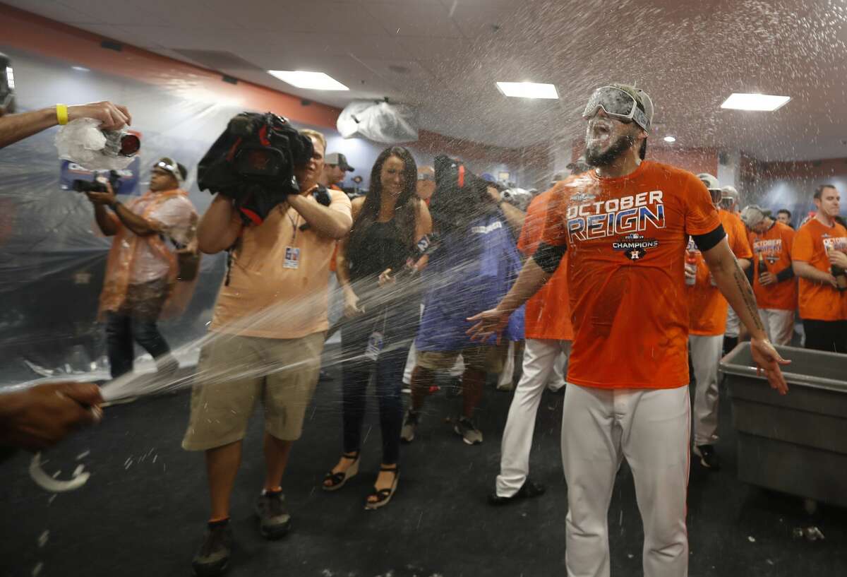 Houston Astros relief pitcher Roberto Osuna gets sprayed by champagne as the team celebrated the team's win and clinching the AL West crown in the clubhouse after an MLB baseball game at Minute Maid Park, Sunday, Sept. 22, 2019, in Houston.