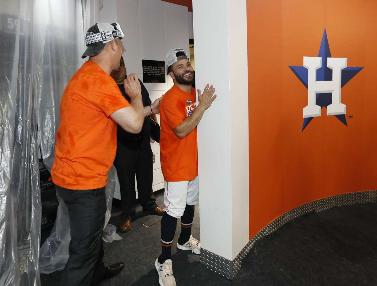 Houston Astros Jose Altuve hides behind a wall as the team celebrated the team's win and clinching the AL West crown in the clubhouse after an MLB baseball game at Minute Maid Park, Sunday, Sept. 22, 2019, in Houston.