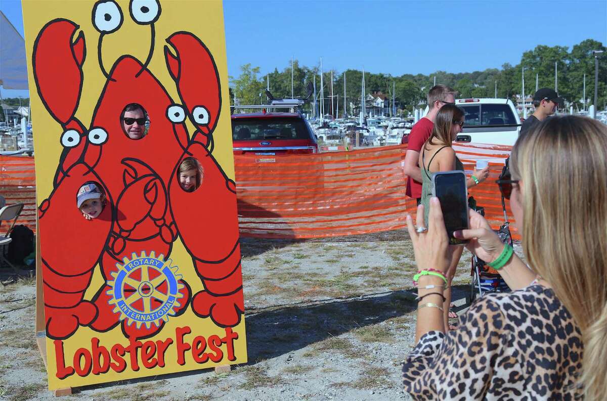 Gillian Libby of Westport gets a picture of her family, including Matt Libby, Henry, 4, and Sutton, 7, at the 8th annual Lobster Fest at Compo Beach on Saturday, Sept. 21, 2019, in Westport, Conn.