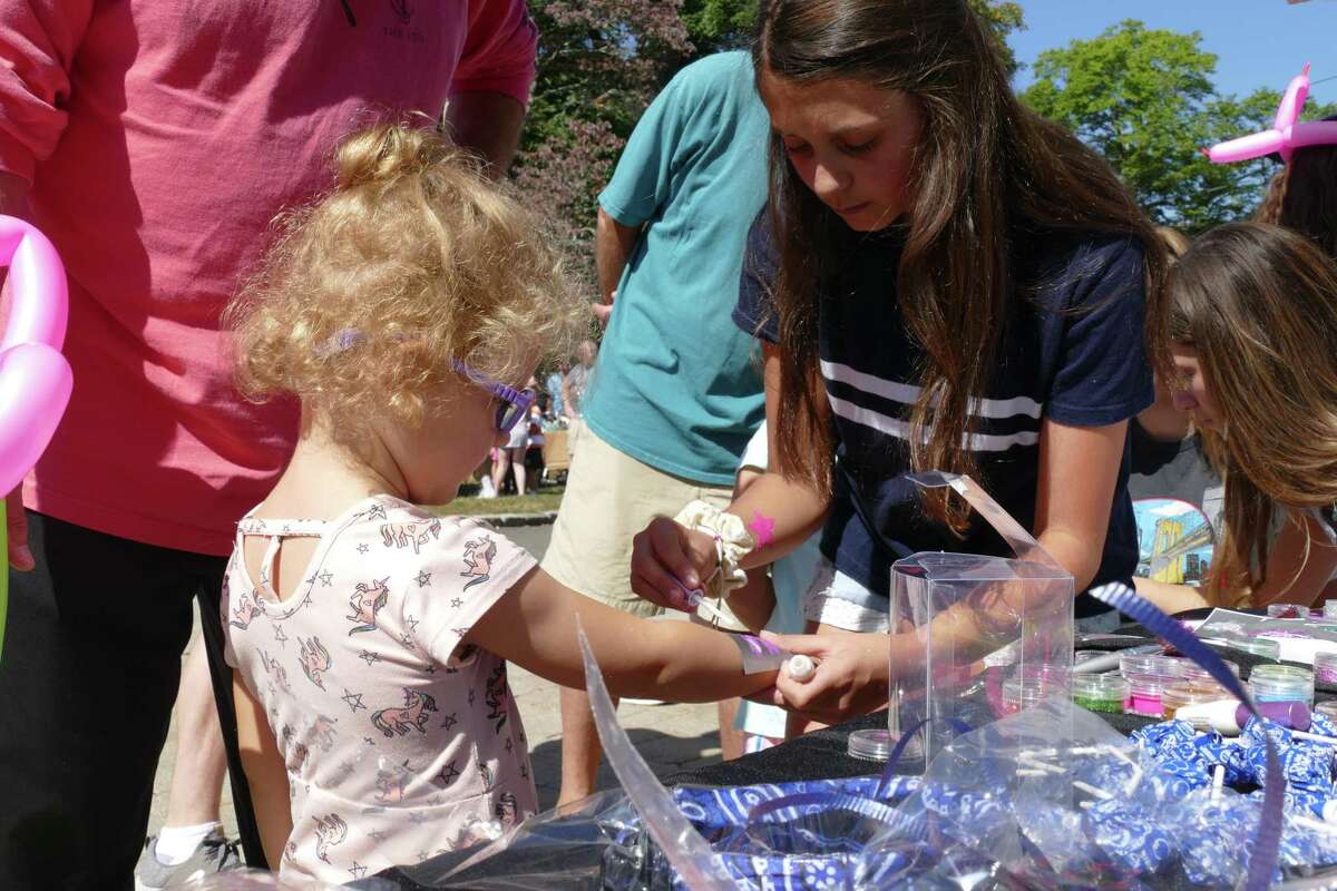 Eva, 3, receives a purple fairy tattoo at Family Fun Day in Ridgefield on Sunday, Sept. 22, 2019.