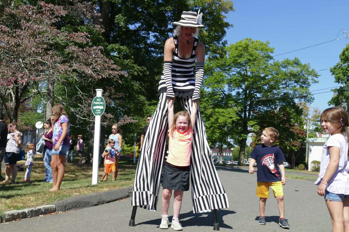 Lylah, 6, gets pulled up by stilt walker Cynthia Rauchert during Family Fun Day at the Lounsbury House on Sunday, Sept. 22.