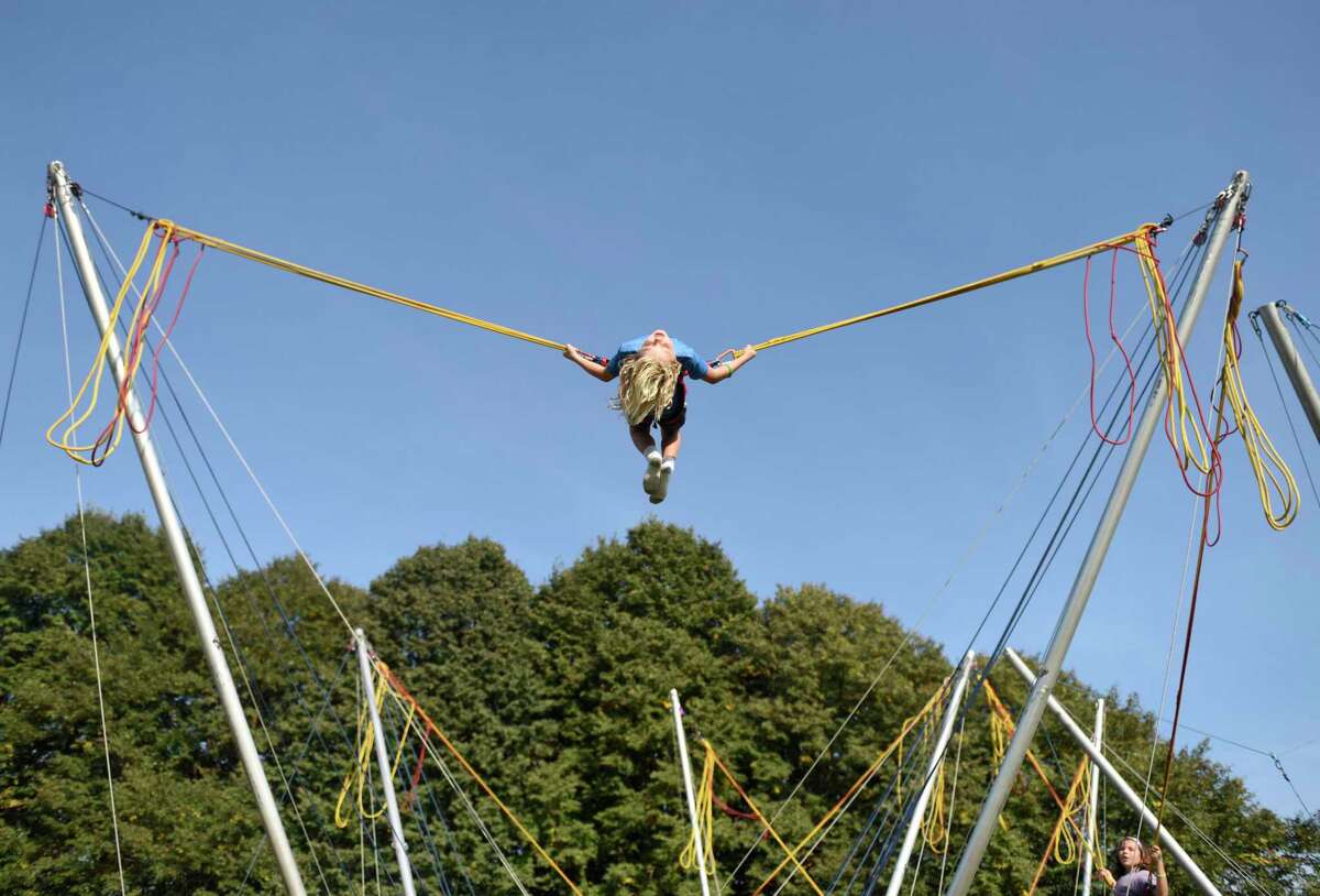 Greenwich's Rocky Gulli, 7, flips upside-down on a bungee trampoline at the 20th annual Go Wild! Family Field Day at the Greenwich Polo Club in Greenwich, Conn. Sunday, Sept. 22, 2019. The event featured a variety of fun outdoor activities including hot air balloon rides, pony rides, bungee trampolines, a climbing wall, pick up soccer games, live music and more, as well as a selection of food trucks. The event supports GLT's ongoing land stewardship efforts and general operational costs.