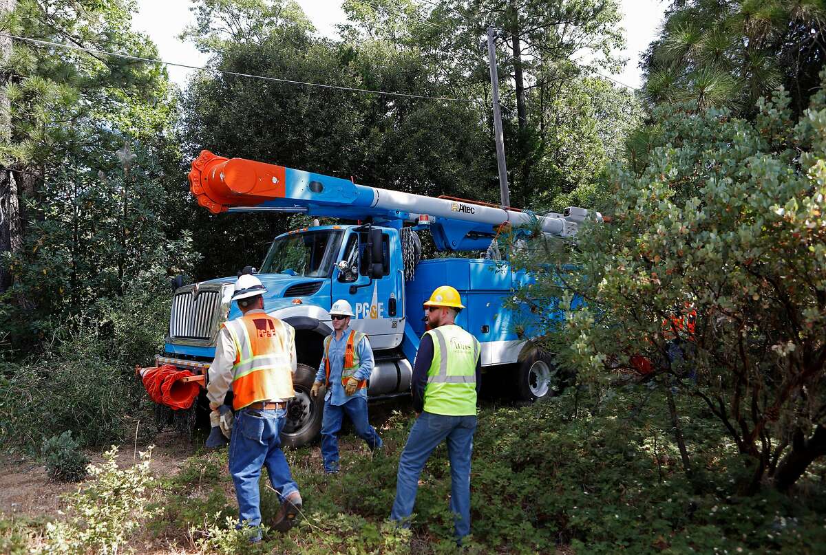 A PG&E crew navigates the thick brush to make a power line repair, as PG&E performs a public safety power shutoff drill around Foresthill, Ca. on Thurs. August 8, 2019, Helicopters and trucks, are used in a trial run for how it will inspect power lines before turning them on after a shut down.