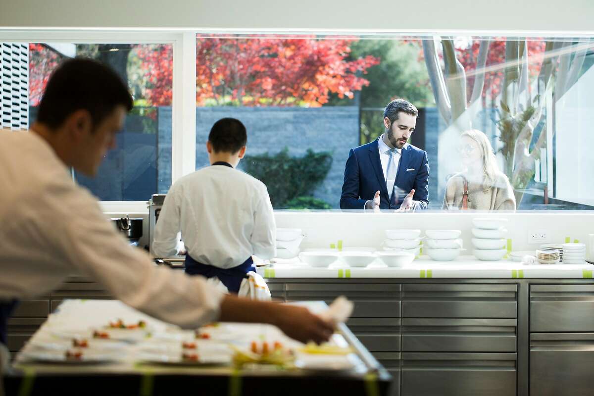 Maitre d� Nick Fitch describes the kitchen operations to a patron through the glass at the newly remodeled and expanded French Laundry in Yountville, Calif. on Saturday, Dec. 9, 2017.