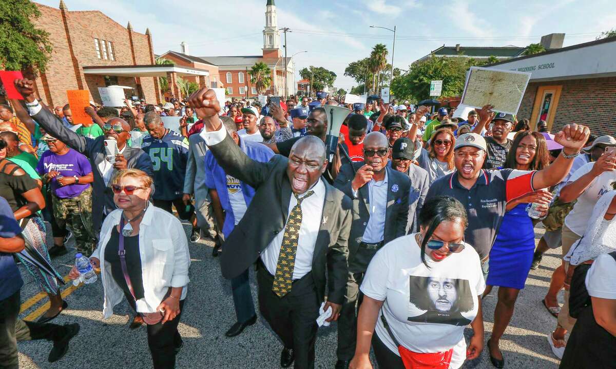 Attorney Benjamin Crump (center) and the Bishop James Dixon (behind) lead supporters of Donald Neely, the disabled man arrested by two mounted Galveston police officers, on a march down 23rd Street Sunday, Sept. 15, 2019, in Galveston. Marissa Barnett, City of Galveston, estimated about 250 gathered for the protest.