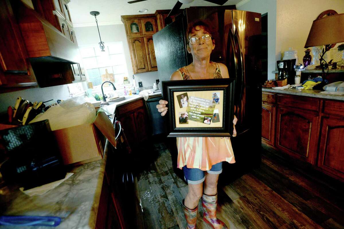 Sheila Hight shows a photo of her husband, which she'd placed up high to keep from potential damage as she begins clean-up from several inches of flooding inside her River Bend Road home in Bevil Oaks, whose evacuation order was lifted late Sunday. Many residents were already in the process of clearing out and gutting their homes Monday morning. Hight's home got over six feet of flooding in Harvey, but she and husband Ernie were able to repair. "You should have seen my house. It was beautiful," she said. Hight lost her husband in January to cancer, "and now I'm doing this again. So it's rough." Photo taken Monday, September 23, 2019 Kim Brent/The Enterprise