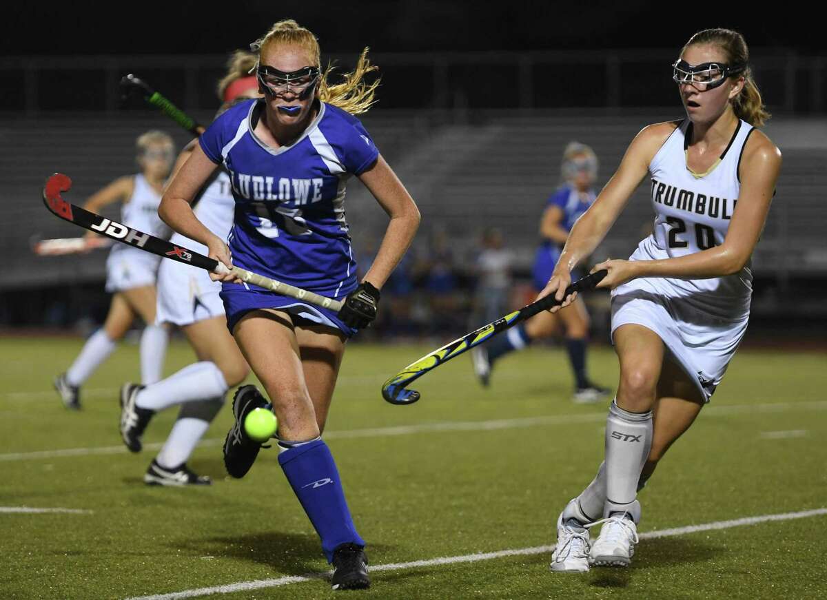 Fairfield Ludlowe's McKalynn Jacobsen, left, goes after the ball in front of Trumbull's Ella Consla in the first half of their FCIAC field hockey game on Monday in Trumbull. Ludlowe won 2-1.