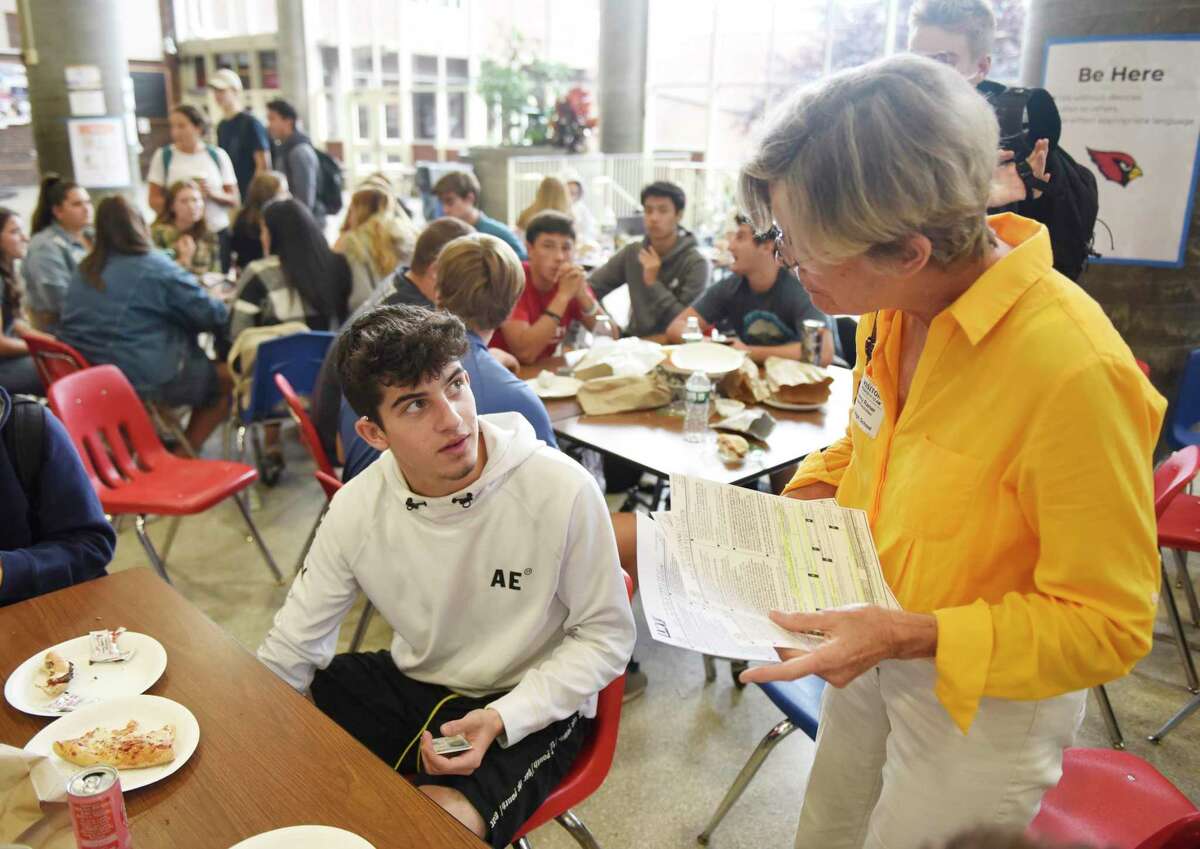 League of Women Voters member Nancy Ramer helps senior Teddy Hasapis register to vote during the lunch break at Greenwich High School in Greenwich, Conn. Tuesday, Sept. 24, 2019. League of Women Voters representatives visited GHS during lunch to help eligible students register to vote in the upcoming election on Nov. 5.
