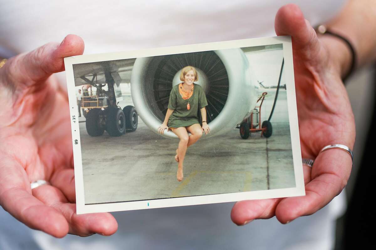 Former Flying Tigers flight attendant Joan Arthur shows off a photo of herself as a young flight attendant posing for a photo on an airplane engine in San Francisco, California, on Wednesday, Sept. 18, 2019. The former flight attendant flew U.S. troops to Vietnam during the Vietnam War.