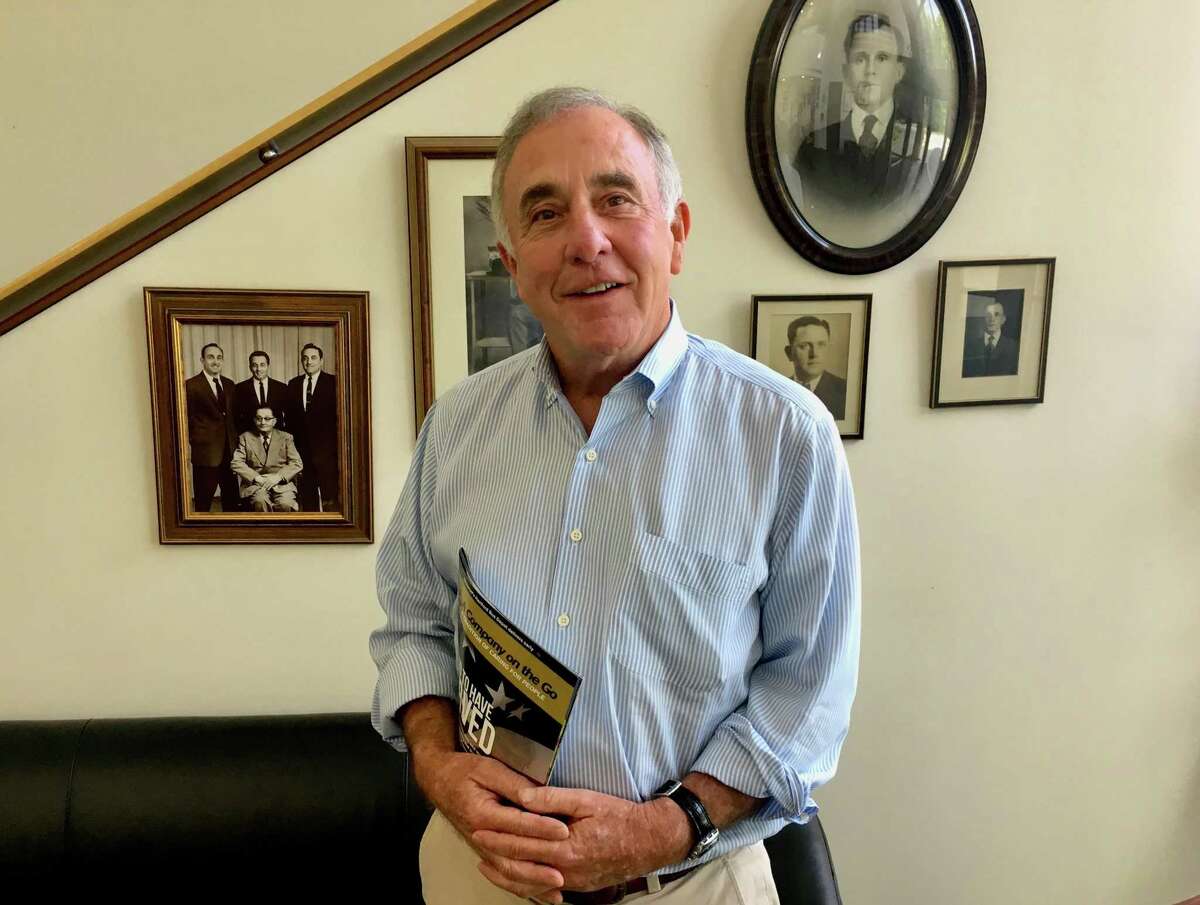 David Oneglia, president of O&G Industries Inc., is one of three family members that head the giant construction firm as they prepare to pass it to the next generation. He's shown at the company's Torrington headquarters lobby with photos of his grandfather, Andrew Oneglia, the founder, and other early executives.