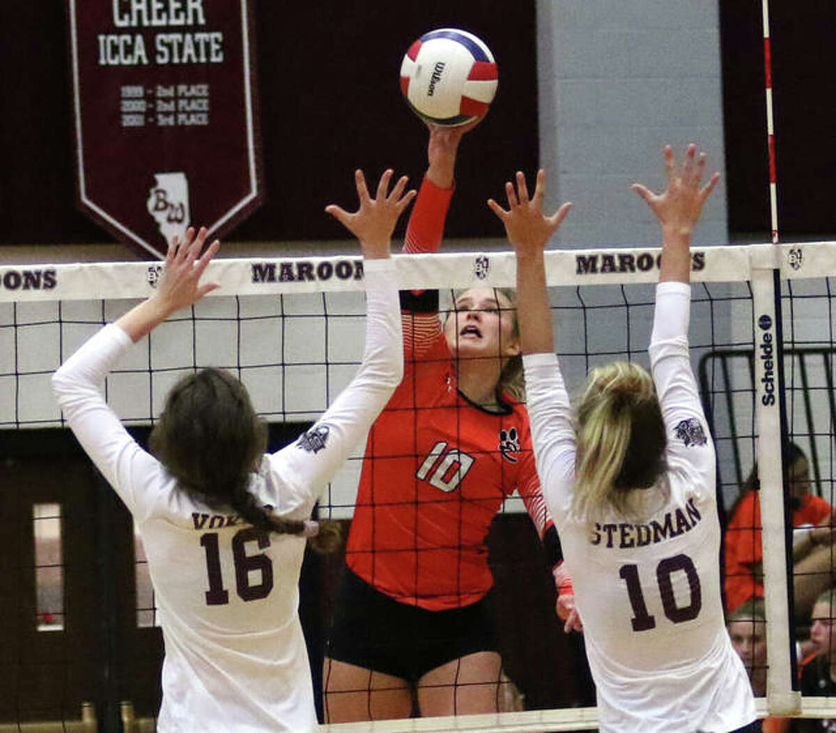 Edwardsville sophomore Emma Garner (middle) hits for one of her five kills in the third set before Belleville West’s Sydney Vokes (16) and KC Stedman (10) can rise up for a block on Tuesday night at Belleville.