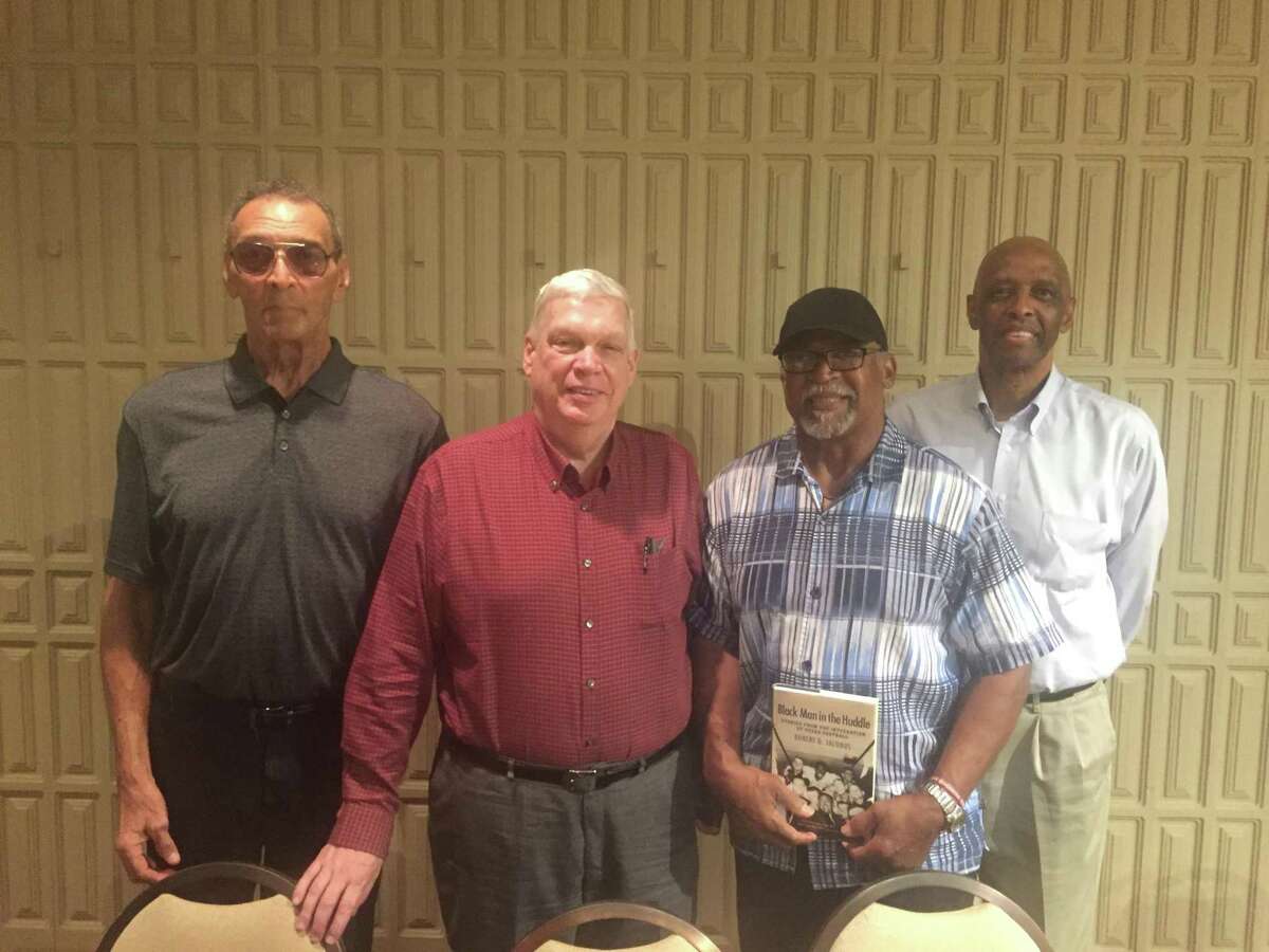 Tony Guillory, Robert Jacobus, Joe Brown and Michael Hurd pose for a picture in the Plummer Room of Lamar University's library after participating in a discussion about the history African American football players in Texas. Photo by Matt Faye/The Enterprise.