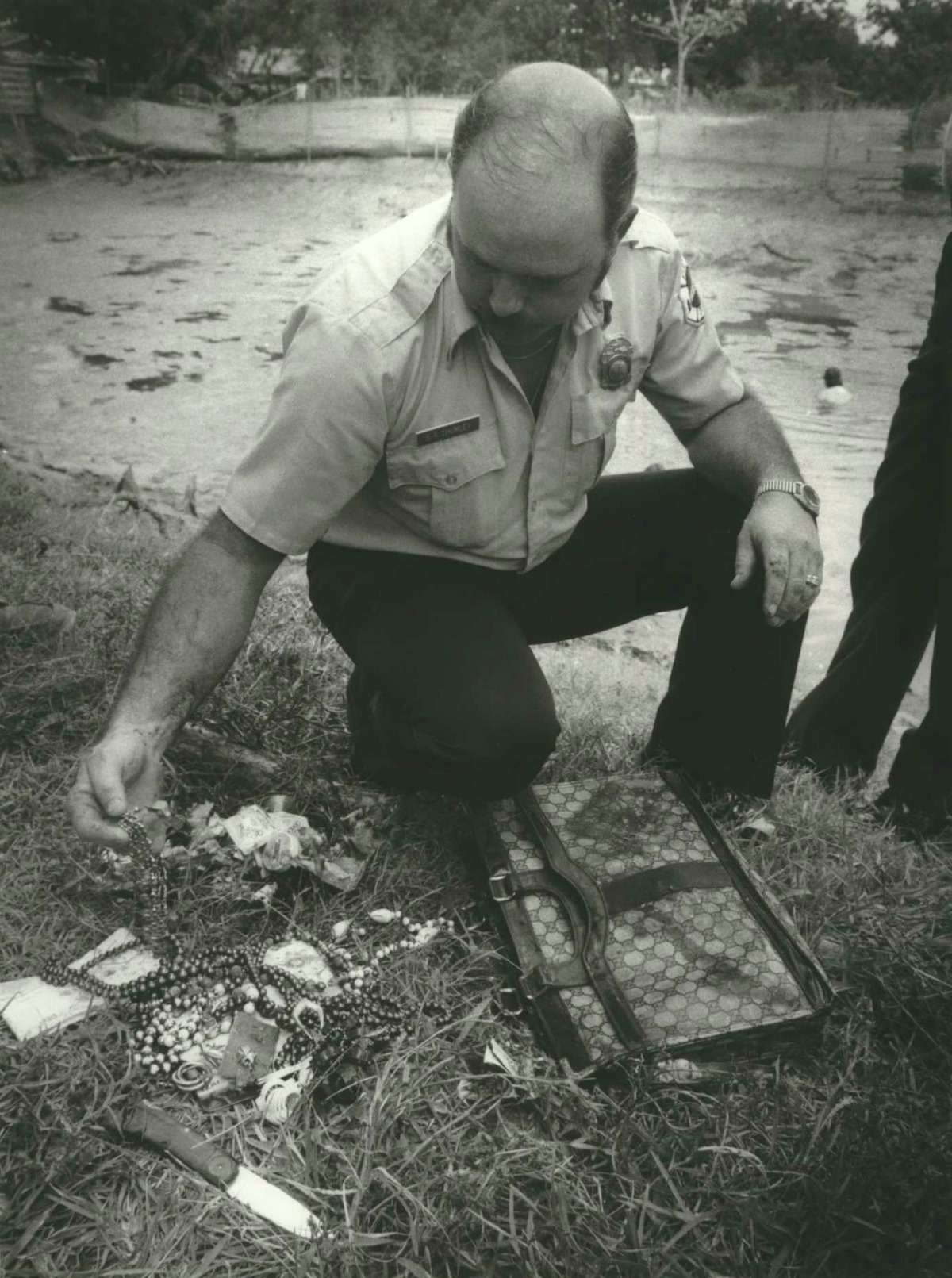 Sept. 14, 1984: Houston Capt. S.R. Chumley of the Houston Fire Department looks at jewelry and a purse and knife found by HPD drive team in a pond in the 2000 block of Charles. Police divers, investigating a burglary ring, found a knife and a purse containing what appeared to be costume jewelry at the bottom of a pond at 2010 Charles. The house at that address has no connection with the ring, police said. Officers believe the burglary ring was involved in the attempted capital murder of a police sergeant who tried to arrest members of the group several weeks prior. He was shot at, but not hit. Investigators had expected the pond to be 25 feet deep, but it has dried to the 6-foot level. The Fire Department pumped out most the water, and police used a metal detector to search for evidence.