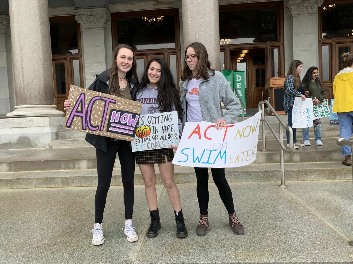 Ridgefield High School students Michaela Fitzgerald, Hannah Boylan, and Victoria Gibian hold up protest signs with environmentalist and author Leticia Colon de Mejias at the Youth Climate Strike in Hartford March 15.