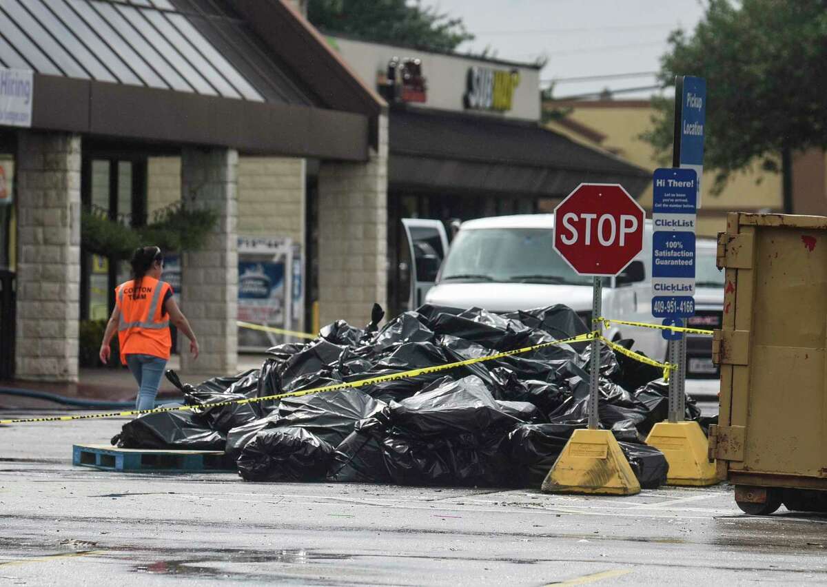 Bags of trash sit in front of the Kroger store, Friday, Sept. 20, 2019 in Beaumont, Texas. East of Houston in Jefferson County, which got hit by more than 40 inches of rain, officials also began taking stock of their damage. (Ryan Welch/The Beaumont Enterprise via AP)