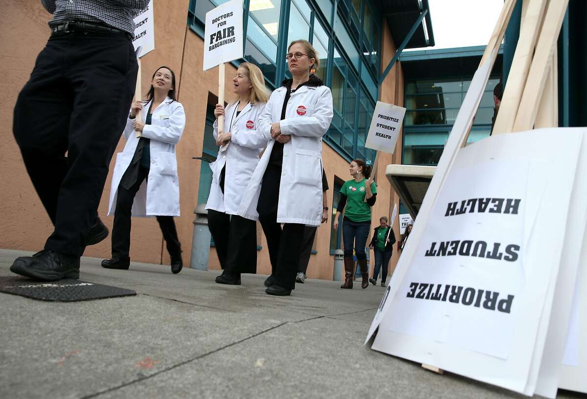 Medical doctors Leslie Gee (left), Annie Hope (center), and Odile Arizmendi on a picket line in front of the University Health Services clinic at UC Berkeley during a one-day strike on all ten University of California campuses in 2015. Contra Costa County doctors may strike for the first time in their union's history as early as next month.
