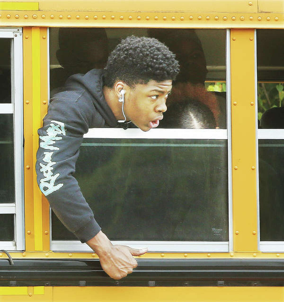One of many Alton High School students on a bus in an accident involving a Nissan Rogue and a motorcyclist on Wednesday watches as firefighters take the male motoryclist to Alton Memorial Hospital where an ARCH Air Medical Services Inc. helicopter met them. The motoryclist appeared to be in serious condition at the scene. None of the students on the school bus were injured.