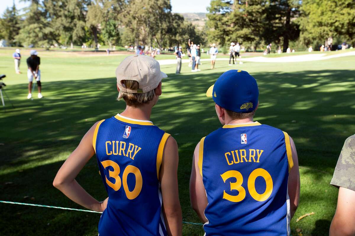 Some young fans of Golden State Warriors star Stephen Curry watch their idol play his approach shot at the 17th hole during the Safeway Open pro-am golf event on Wednesday, Sept. 25, 2019 in Napa, Calif.