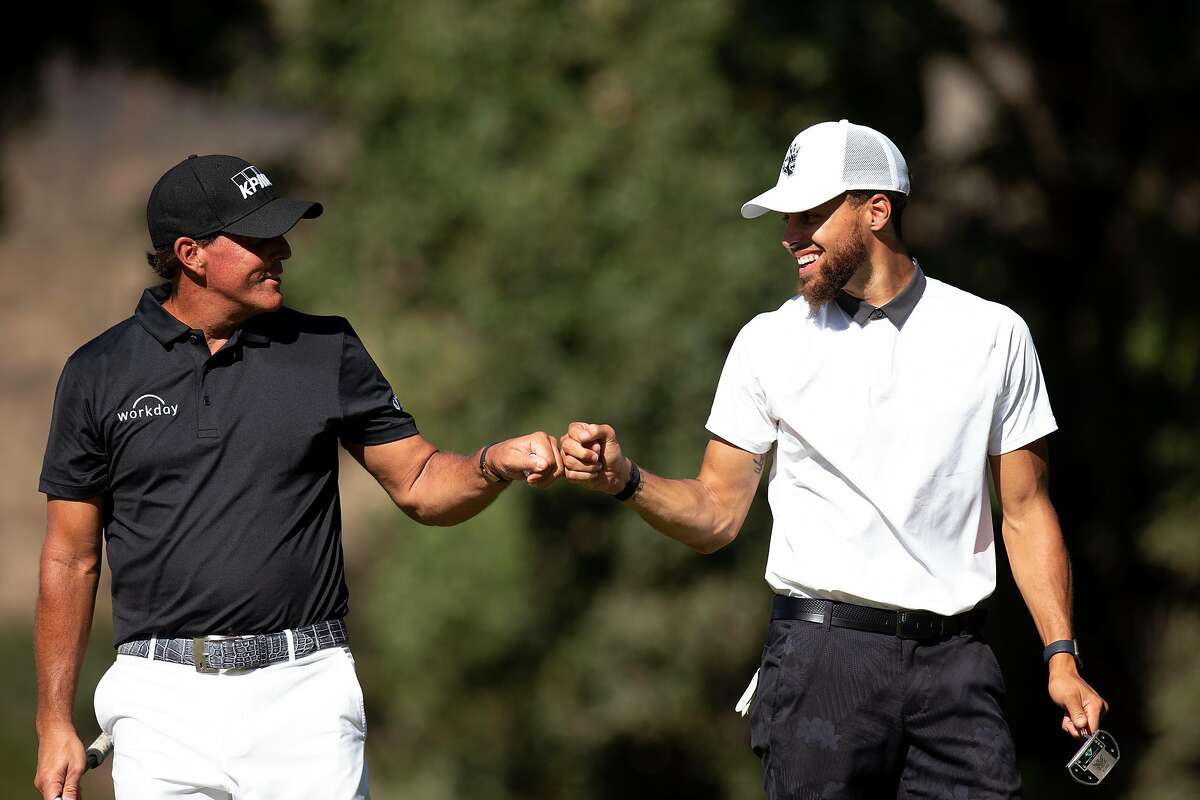 Phil Mickelson, left, and Golden State Warriors star Stephen Curry share a fist bump during the Safeway Open pro-am golf event on Wednesday, Sept. 25, 2019 in Napa, Calif.