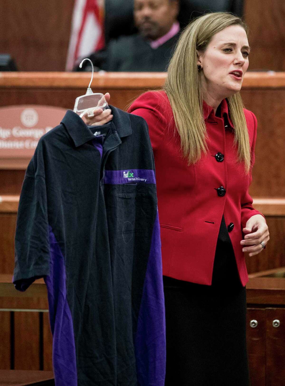 Prosecutor Samantha Knecht holds up a FedEx shirt, which was entered as evidence earlier in the trial, during the closing arguments in Ronald Haskell's capital murder trial on Wednesday, Sept. 25, 2019, in Houston. Haskell is charged with capital murder in connection with the 2014 massacre of a Spring family.