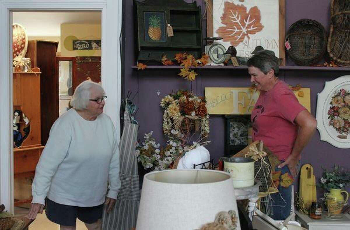 Diane Lentner, right, helps out a customer at Simply Prim and Farmhouse. She and Luann Blackstock opened the home decor store back in August. (Robert Creenan/Huron Daily Tribune)