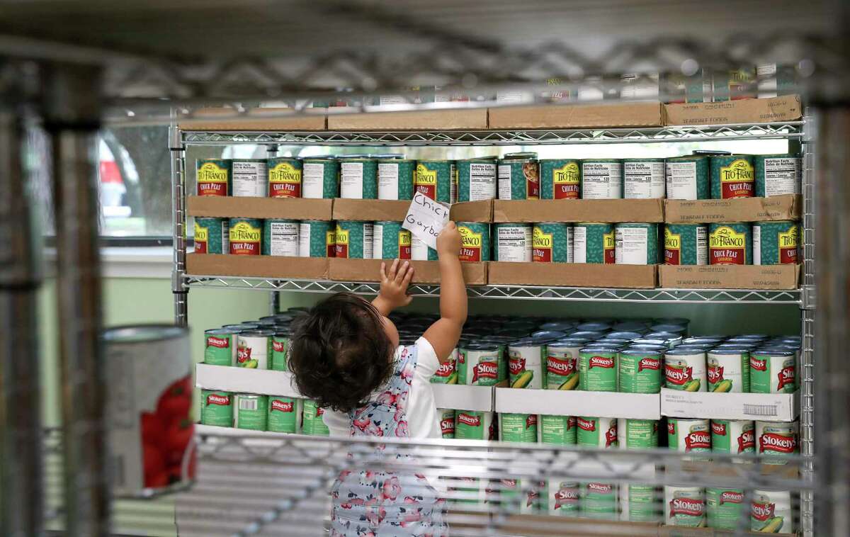 Gimena Martinez, 2, explores the food pantry at Epiphany Community Health Outreach Services in the Braeburn area.