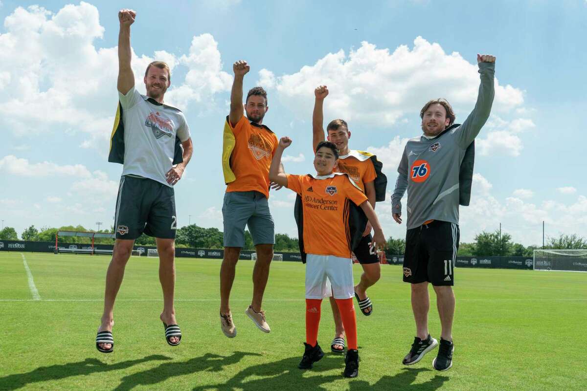 Dynamo players jump with a ‘Kick Childhood Cancer!’ patient