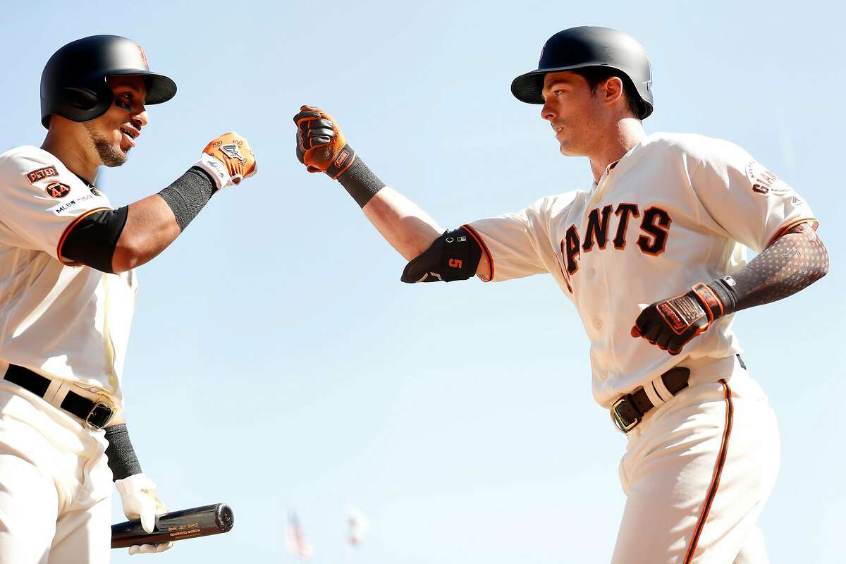 San Francisco Giants' Mike Yastrzemski fist bumps Cristhian Adames after his 4th inning home run against Colorado Rockies during MLB game at Oracle Park in San Francisco, Calif., on Thursday, September 26, 2019.