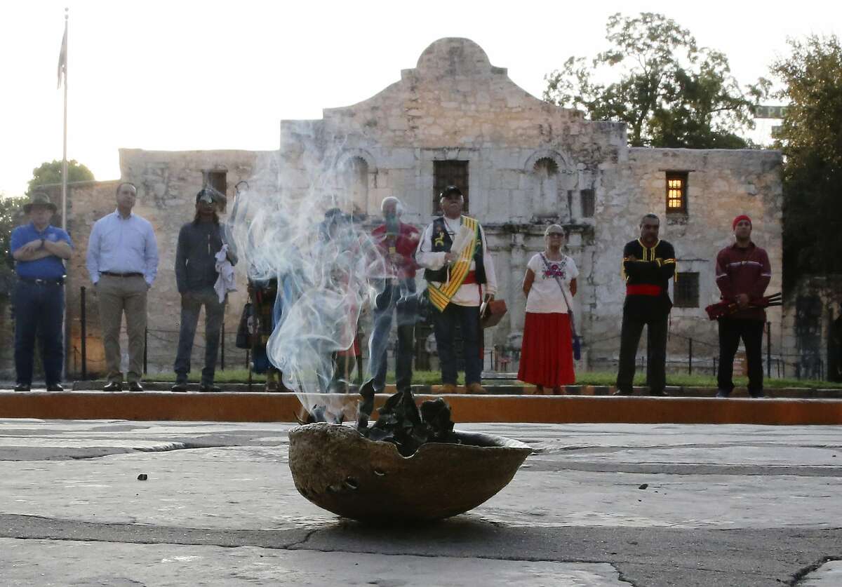 A local Native American group honored buried descendants during their 25th Annual Sunrise Ceremony at the Alamo on Saturday, Sept. 7, 2019. Ramon Juan Vasquez, executive director of American Indians in Texas at the Spanish Colonial Missions, along with over 60 people who many have ancestry with the Native Indians buried on the grounds of the Alamo, formed a circle in front of the church to pray and to honor their descendants. In the past, the group held the service inside the chapel but were told days before the event that the service would not be permitted inside the Alamo. With a noticeable presence of Alamo security officers and chains blocking the walkways to the front doors, the group formed a circle on Alamo Plaza to air their grievances and to remember their descendants. The group was joined by State Senator Jose Mendendez, State Rep. Leo Pacheco and Poet Laureate Carmen Tafolla who all expressed dismay that the indigenous group would not be allowed to pray and honor their loved ones inside the Alamo. Despite the prohibition, members of the Tap Pilam Coahuiltecan Nation and other indigenous people paid their respects on the ground by the front of the Alamo. A shell filled with sage slowly burned and filled the early morning sky with wafts of smoke - which traditionally serves to bless and purify - as the service ended as the sun slowly rose over the Alamo. (Kin Man Hui/San Antonio Express-News)