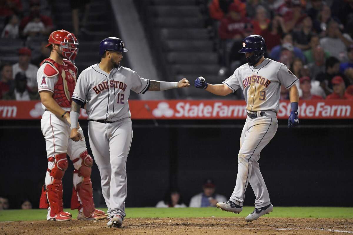 Houston Astros' Jack Mayfield, right, is congratulated by Martin Maldonado, center, after hitting a two-run home run, while Los Angeles Angels catcher Kevan Smith stands at the plate during the fifth inning of a baseball game Thursday, Sept. 26, 2019, in Anaheim, Calif. (AP Photo/Mark J. Terrill)