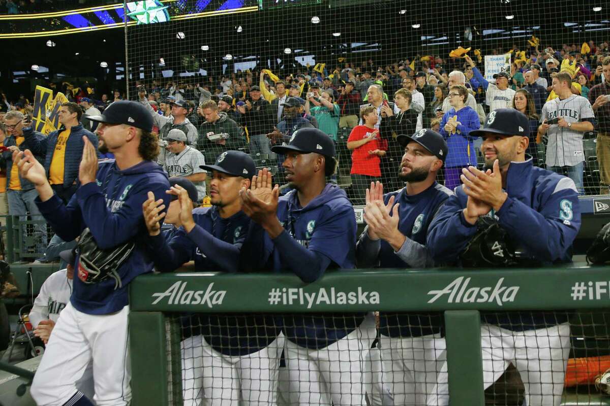 Seattle Mariners players clap for starting pitcher Felix Hernandez as walks across the field for what is likely his final start in their game against the Oakland Athletics, Thursday, Sept. 26, 2019.