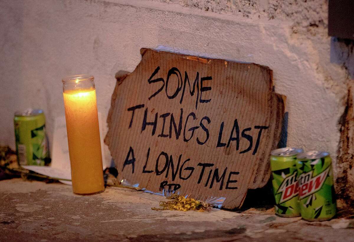 A candle burns next to a sign bearing the name of a song by musician and artist Daniel Johnston at a memorial at a mural he painted on Wednesday, Sept. 11, 2019, in Austin, Texas. Johnston, a quirky folk singer-songwriter and visual artist whose offbeat career and struggles with mental illness brought him a cult following and inspired a documentary film, has died Wednesday at age 58. (Nick Wagner/Austin American-Statesman via AP)