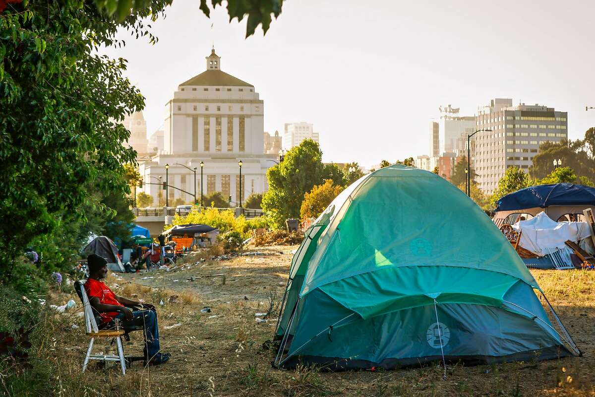 Ollie Harris, 69, sits outside his tent at an encampment on East 12th Street in Oakland, California, on Wednesday, July 24, 2019. Ollie and his partner Debbie are currently homeless. They went through Oakland's Tuff Shed program where they resided before getting permanent housing in Stockton. After spending a month in an apartment in Stockton the couple moved back to an encampment in Oakland because they claimed the apartment was infested with rats and cockroaches.