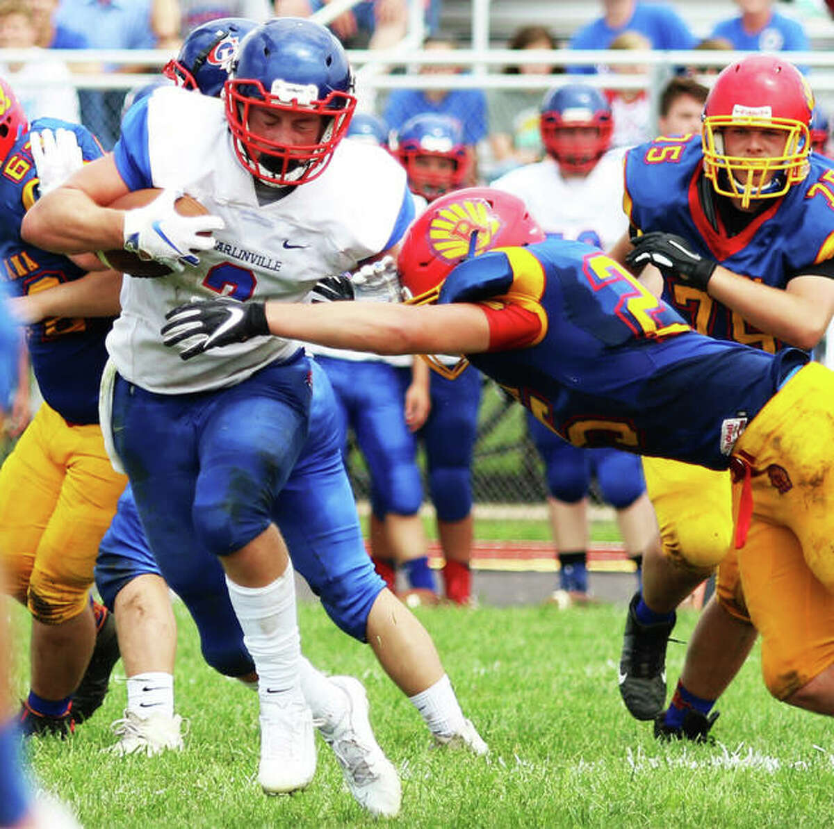 Carlinville’s Colton DeLong (left), shown trying to elude Roxana’s David Pluester in a SCC game in Week 1 at Roxana, rushed for 232 yards and four touchdowns Friday night in the Cavaliers’ SCC victory over Staunton in Carlinville.