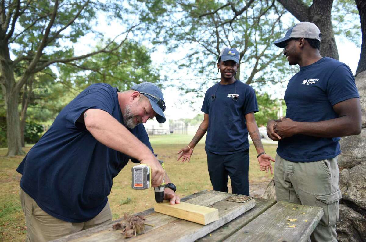 Program instructor Josh Mayo, left, works with recent high school graduates Donovan Carter, center, and Jeremiah Davis at the SoundWaters Harbor Corps marine job training program at John J. Boccuzzi Park in Stamford, Conn. Thursday, Sept. 26, 2019. In partnership with DOMUS, recent Stamford Public Schools graduates learn valuable technical skills and connect with marine industry leaders to learn of career opportunities on the Stamford waterfront. This fall, members are restoring a catboat, and in the process learning fiberglass repair, carpentry, painting, varnishing, rigging, engine maintenance and more.