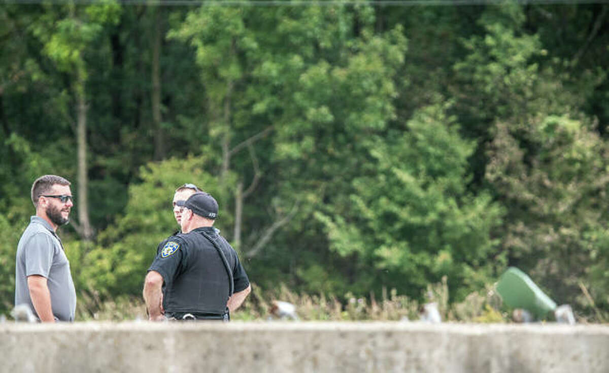 Alton police speak to a man near the scene of a fatal motorcycle crash on the Homer Adams Parkway extension Saturday afternoon.