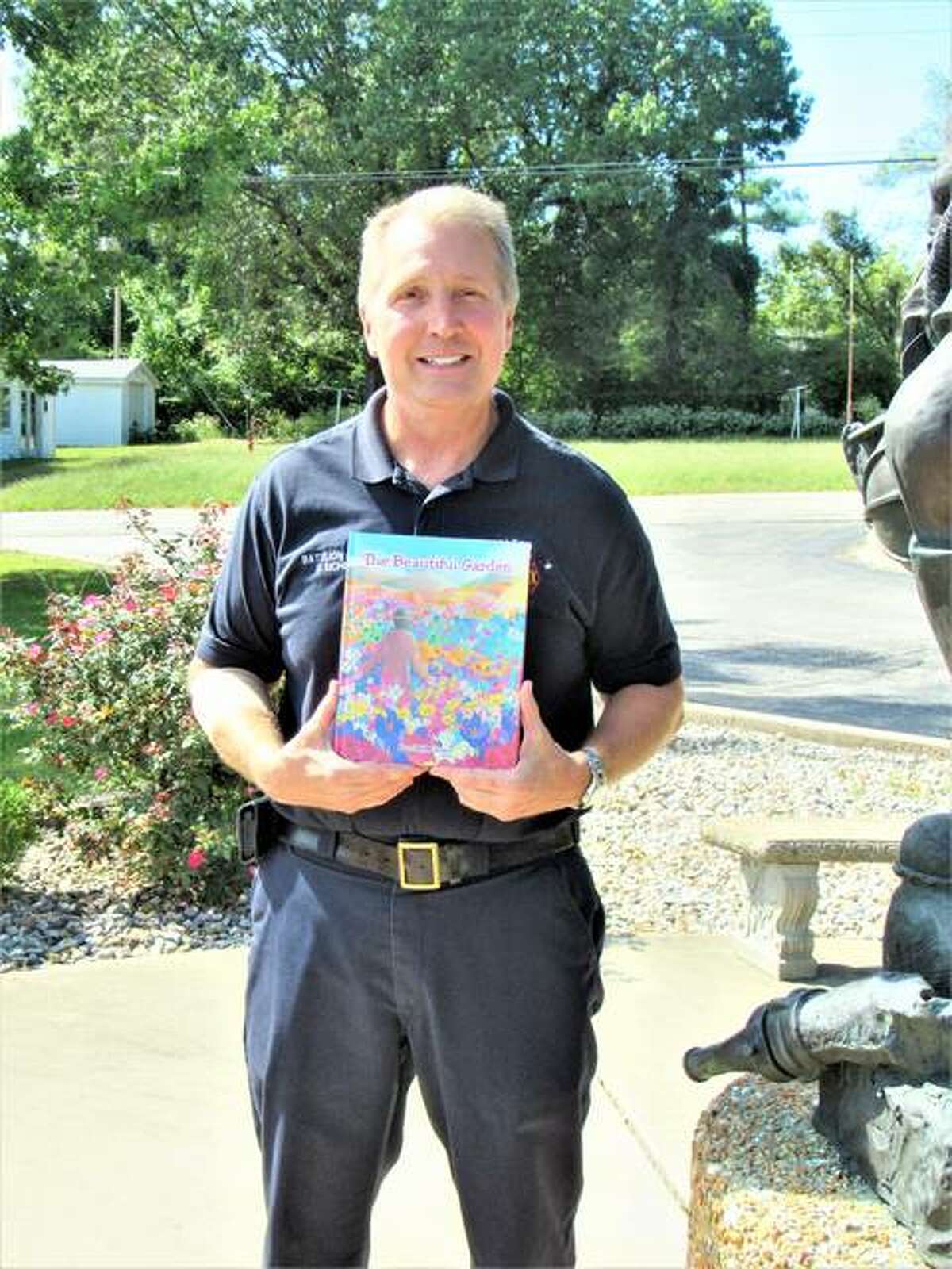 Alton Fire Department Battalion Chief Dave Eichen holds a copy of his children’s book about respect for others, “The Beautiful Garden,” which became available July 23.