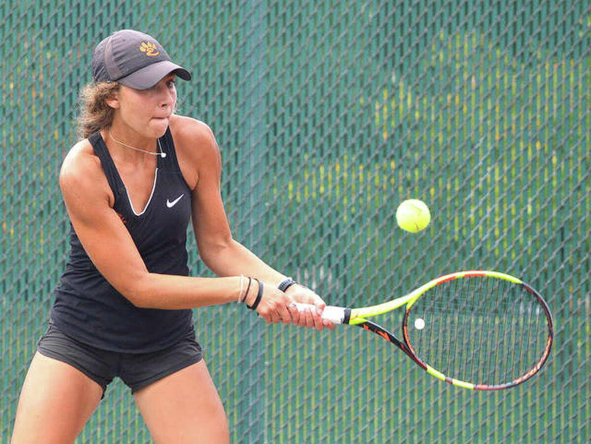 Edwardsville’s Hayley Earnhart makes a backhand return during her No. 6 singles match against Triad’s Kyle Triplo Wells on Saturday during the Southern Illinois Duals at the EHS Tennis Center.
