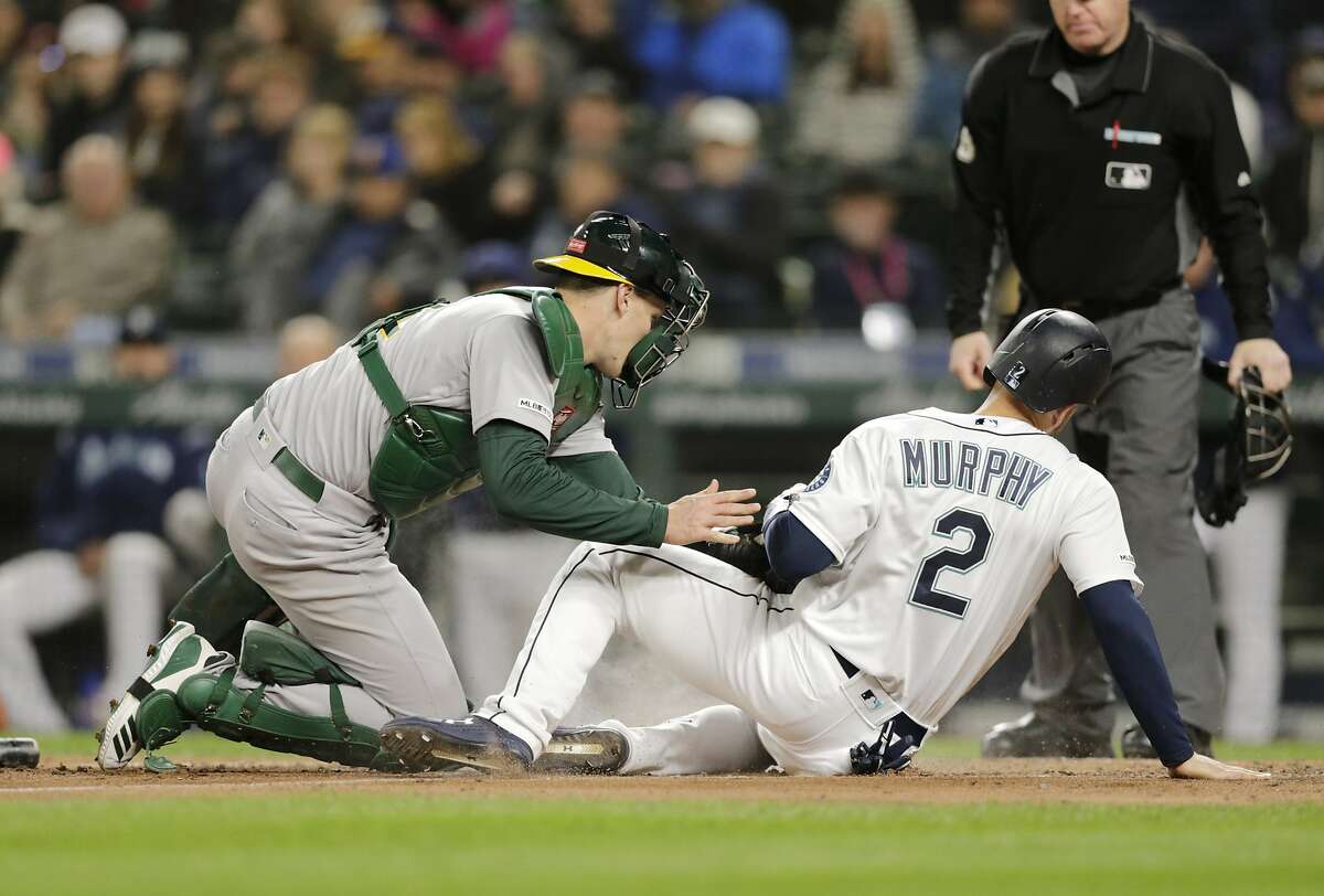 Seattle Mariners catcher Tom Murphy motions toward the field