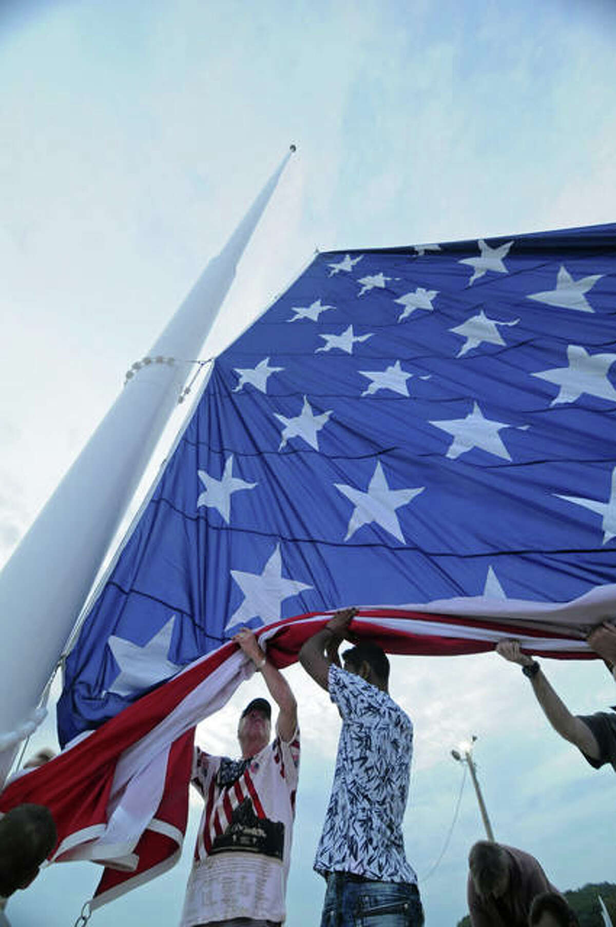 A team of veterans and first responders begin to hoist a giant flag in Grafton for the first time on Saturday. An estimated 1,000 people attended the ceremony for the 40-by-80-foot American flag that will fly from a 130-foot flag pole in Grafton Lighthouse Park at the confluence of the Mississippi and Illinois Rivers.